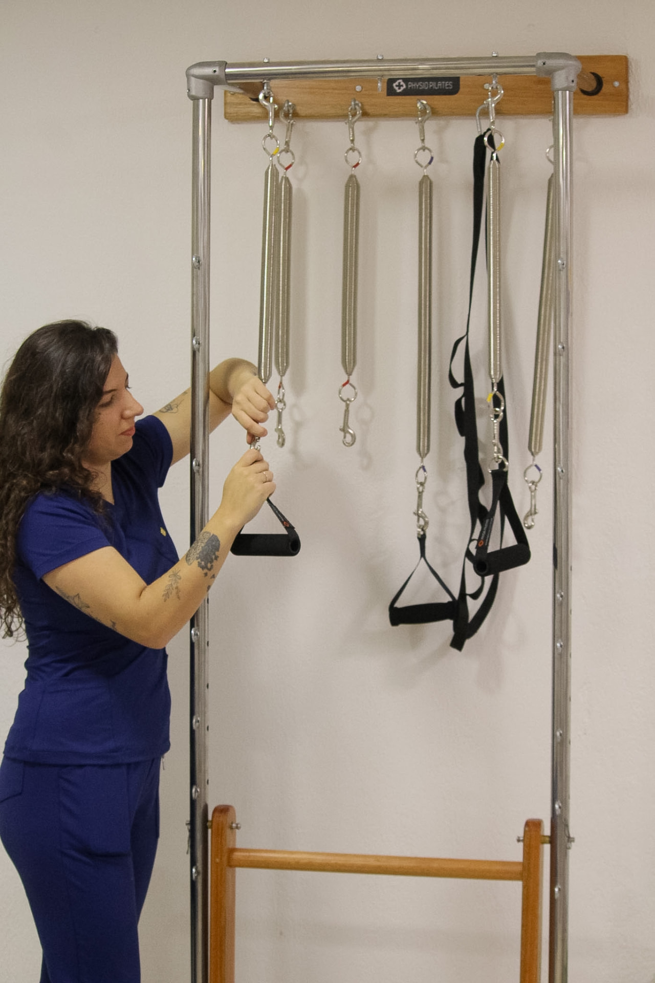 Fisioterapeuta ajustando molas do Wall Unit de Pilates